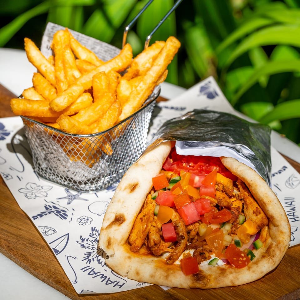 Tiki Fish n Burgers' chicken gyro with fresh tomatoes, peppers, and a side of golden fries.