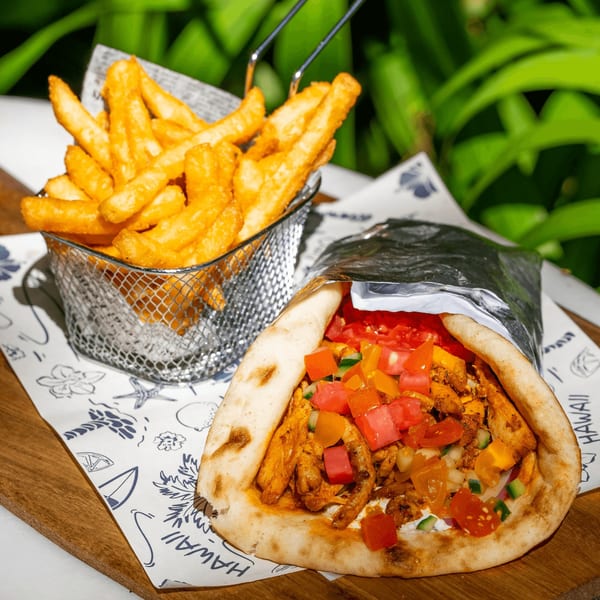 Tiki Fish n Burgers' chicken gyro with diced tomatoes and peppers, served with a side of fries.
