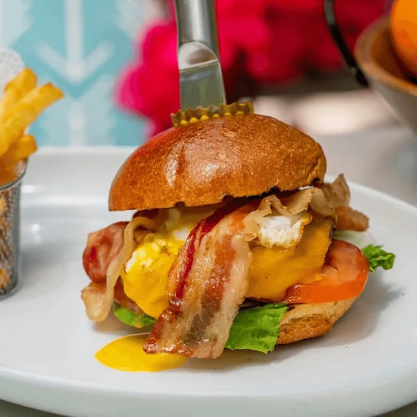 Tiki Fish n Burgers' burger with bacon, egg, cheese, tomato, and lettuce, served with fries.